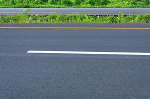 vuoto autostrada con demarcazione linea, ciglio della strada e verde erba, astratto mezzi di trasporto sfondo, asfalto strada nuovo costruzione foto