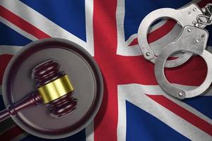 grande Gran Bretagna bandiera con giudice maglio e manette nel buio camera. concetto di penale e punizione, sfondo per giudizio temi foto