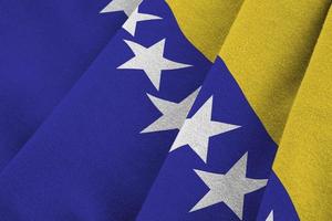 bosnia e erzegovina bandiera con grande pieghe agitando vicino su sotto il studio leggero al chiuso. il ufficiale simboli e colori nel bandiera foto