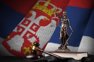 Serbia bandiera con statua di signora giustizia, costituzione e giudice martello su nero drappeggio. concetto di giudizio e colpa foto