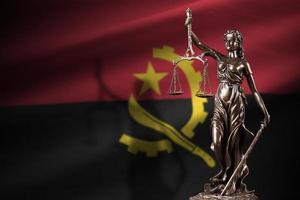 angola bandiera con statua di signora giustizia e giudiziario bilancia nel buio camera. concetto di giudizio e punizione foto