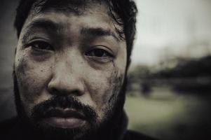 asiatico uomo è senza casa a il lato strada, a sconosciuto ha per vivere su il strada solo perché lui ha no famiglia. foto