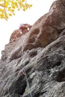 maschio scalatore, giovane uomo-scalatore arrampicata un' difficile itinerario su un' scogliera. scalatore si arrampica un' roccioso parete. con sicurezza corda su il roccia foto