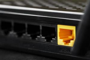 senza fili modem router con giallo cavo e lan porta per connessione su un' nero sfondo. foto