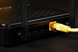 senza fili modem router con giallo cavo e lan porta per connessione su un' nero sfondo. foto