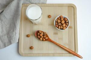 su un' di legno tavola nocciola noccioline e un' bicchiere di latte, il concetto di latte a partire dal noccioline foto