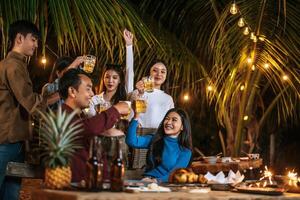 ritratto di contento asiatico amici avendo cena festa insieme - giovane persone tostatura birra bicchieri cena all'aperto - le persone, cibo, bevanda stile di vita, nuovo anno celebrazione concetto. foto