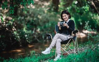 giovane bella donna uso telecamera assunzione foto nel natura parco