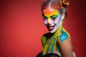 Sorridi giovane signora con un' viso pittura clown foto