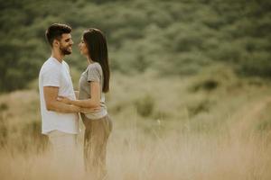 felice giovane coppia innamorata camminando attraverso il campo in erba