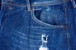 frammento di blu jeans tessuto con un' buco, pieno telaio foto