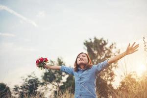 hipster bella donna alzando le braccia in aria con bouquet foto