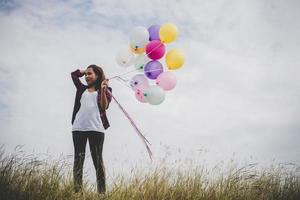 bella donna giovane hipster con palloncini colorati all'aperto foto