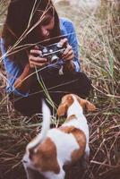 donna hipster che cattura un'istantanea del suo cane sulla sua macchina fotografica vintage foto