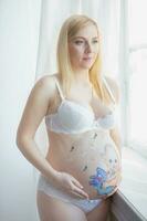 simpatico incinta donna con un' bella disegno su sua stomaco foto