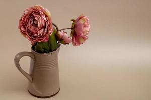 Rose nel un' ceramica brocca su un' beige sfondo con copia spazio, saluto carta