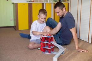 allegro papà giochi con un' carino ragazzo a casa nel macchine foto