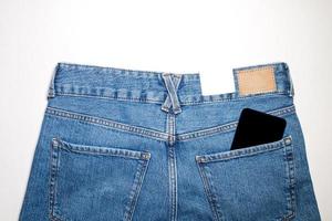 un' moderno Telefono nel il indietro tasca di jeans, visualizzazione il App su un' nero schermo. foto