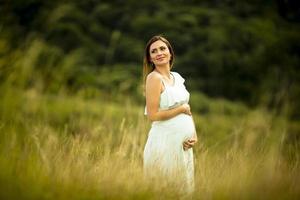 giovane donna incinta rilassante fuori nella natura foto
