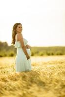 giovane donna incinta in abito bianco rilassante fuori nella natura