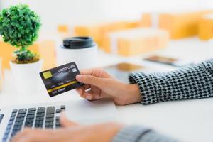 donna utilizzando la carta di credito con il portatile per lo shopping online foto