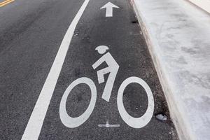 Segno di bicicletta sulla pista ciclabile su strada asfaltata foto