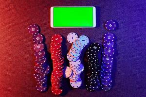 il concetto di un in linea casinò scommesse patatine fritte e un' smartphone con un' verde sfondo con un' copia spazio. superiore Visualizza. foto