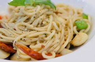 frutti di mare spaghetti piccanti su un piatto bianco foto