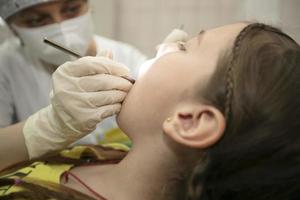 il bambino è essere trattati per denti nel il dentale ufficio.bambino nel il dentista ufficio foto