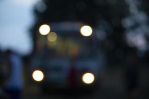 bokeh giallo a partire dal il fari di il autobus su un' buio blu sfondo. foto