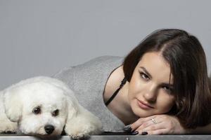 bellissimo ragazza in posa con un' bichon cane. foto