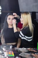 trucco artista mette un' trucco su un' simpatico signora foto