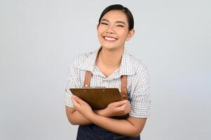 ritratto di giovane asiatico donna nel cameriera uniforme posa con appunti foto