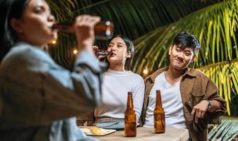 ritratto di contento asiatico amici avendo cena festa insieme - giovane persone tostatura birra bicchieri cena all'aperto - le persone, cibo, bevanda stile di vita, nuovo anno celebrazione concetto. foto