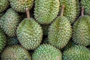 avvicinamento e Ritaglia mucchio di durian su scaffali nel il mercato. foto