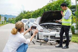 avvicinamento assicurazione azienda ufficiali siamo utilizzando mobile telefoni per prendere fotografie e Radio comunicazione come prova per cliente assicurazione auto reclami su porta sfondo.