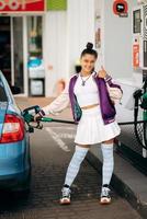 donna Riempimento sua auto con carburante a un' gas stazione foto