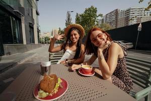 Due giovane bellissimo donne amiche parlando nel un all'aperto bar foto