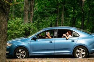 Due amiche scemo in giro e ridendo insieme nel un' auto foto