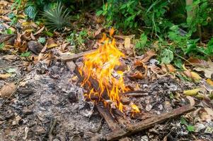 falò impostato nel giorno per ottenere sbarazzarsi di sciocchezze nel pila, fuoco raggiante nel spazzatura pila per mantenere pulito foto