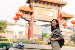 giovane asiatico donna zaino viaggiatore godendo Cina cittadina strada cibo mercato nel bangkok, Tailandia. viaggiatore controllo su lato strade. foto