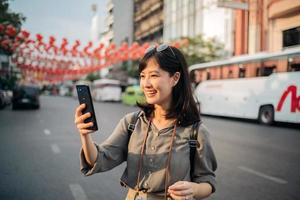 giovane asiatico donna zaino viaggiatore godendo Cina cittadina strada cibo mercato nel bangkok, Tailandia. viaggiatore controllo su lato strade. foto