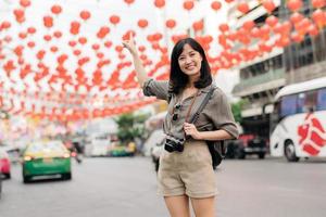 giovane asiatico donna zaino viaggiatore godendo Cina cittadina strada cibo mercato nel bangkok, Tailandia. viaggiatore controllo su lato strade. foto