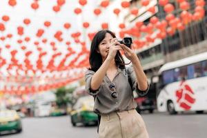 giovane asiatico donna zaino viaggiatore godendo Cina cittadina strada cibo mercato nel bangkok, Tailandia. viaggiatore controllo su lato strade. foto