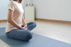 donna seduta meditazione, fare yoga, è solo nel il camera a casa, relax. praticante meditazione yoga e salutare vivente concetti foto
