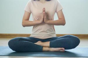 donna seduta nel loto posizione giocare yoga nel il camera con calma e rilassato. foto