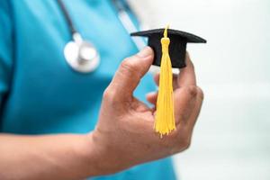 lo studio medico asiatico impara con il cappello del divario di laurea nel reparto ospedaliero, concetto di medicina intelligente per l'educazione del genio brillante. foto