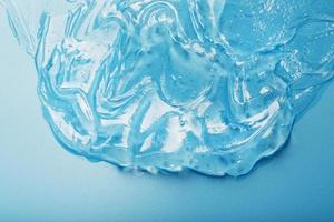 gel con ialuronico acido nel il modulo di un' sbavatura di lucido struttura su un' blu sfondo. foto