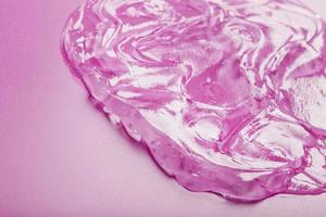 trasparente gel su un' rosa sfondo con gratuito spazio. foto