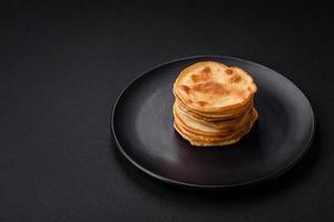 delizioso fresco Pancakes con bacca marmellata su un' nero ceramica piatto foto